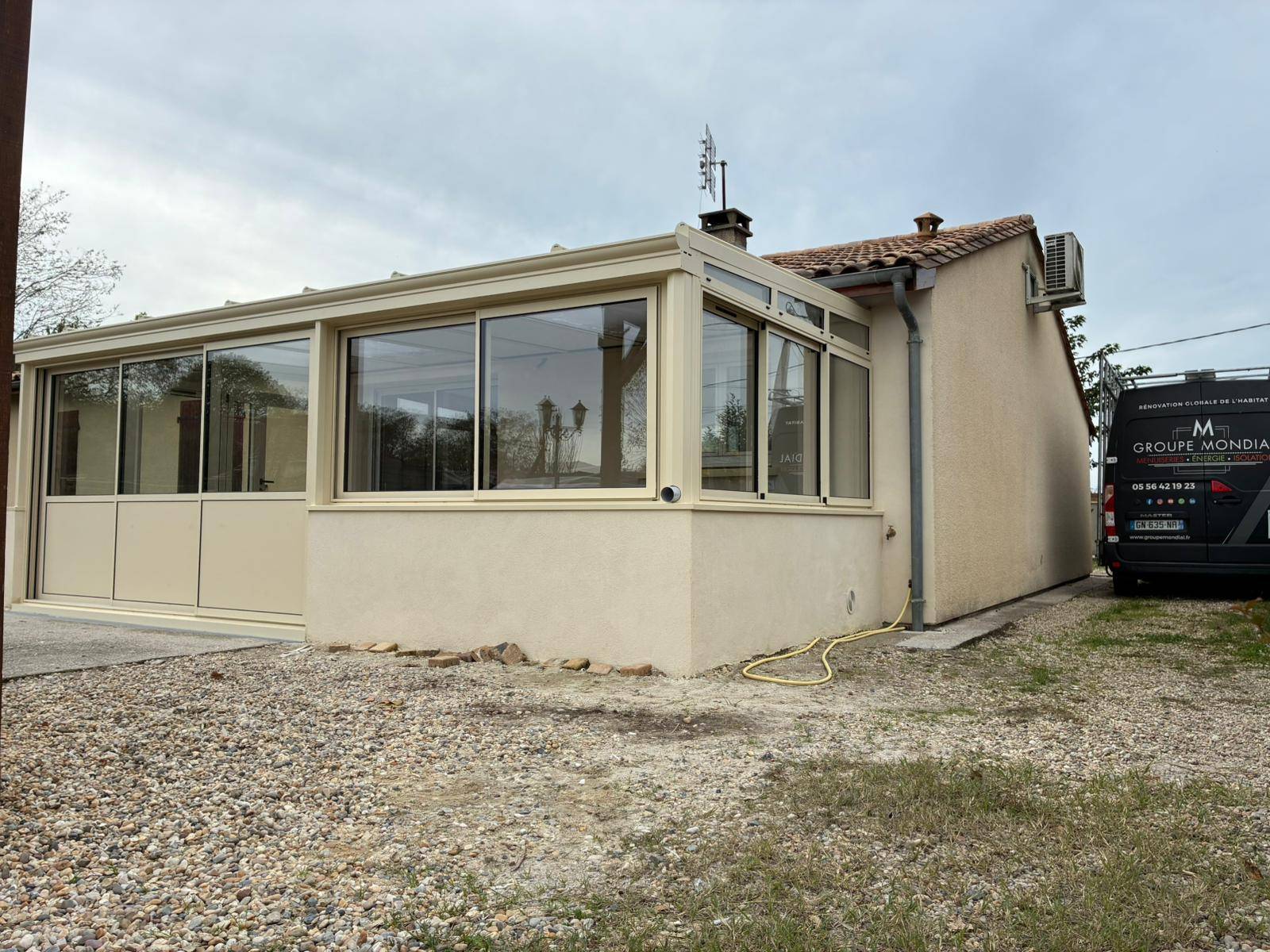 Réalisation à Lamarque : Zoom sur cette véranda en aluminium gris clair équipée d'une toiture mixte quatre saisons.