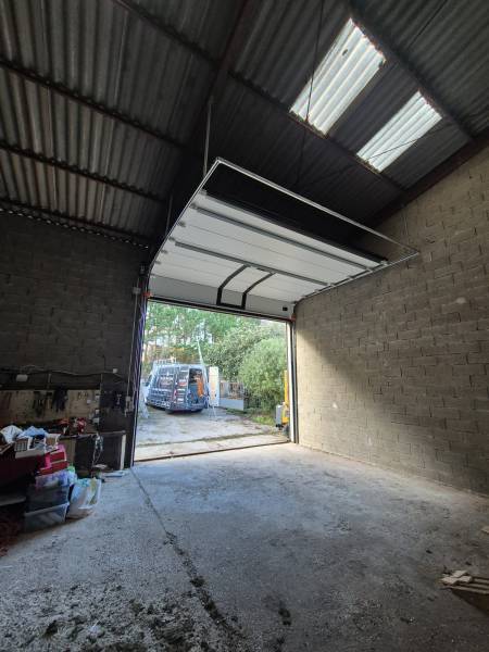 Installation d'une porte de garage sectionnelle avec panneaux sandwichs double paroi pour entrepôt industriel à Gironde sur Dropt