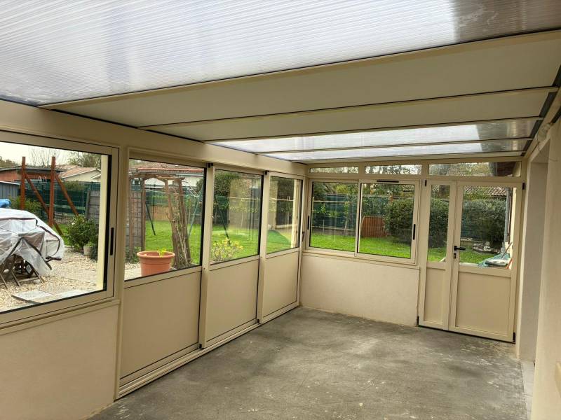 Le jardin s'invite à l'intérieur : Profitez de votre véranda toute l'année grâce à la toiture mixte quatre saisons.